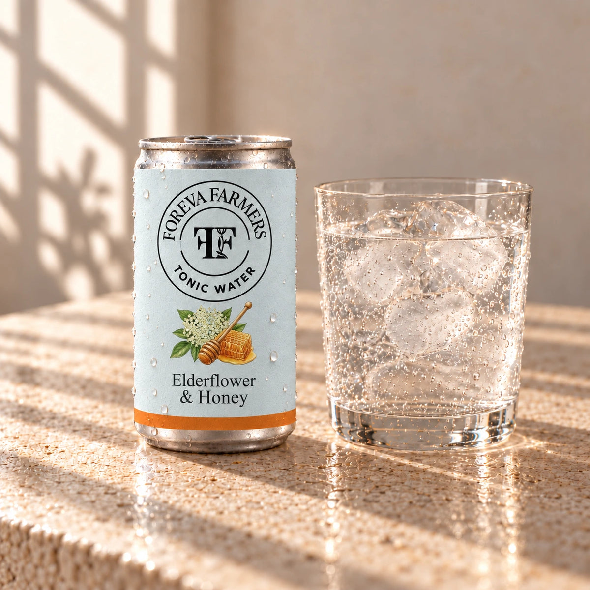 Foreva Farmers Elderflower & Honey Tonic 150ml can with an iced drink on a sunlit stone table