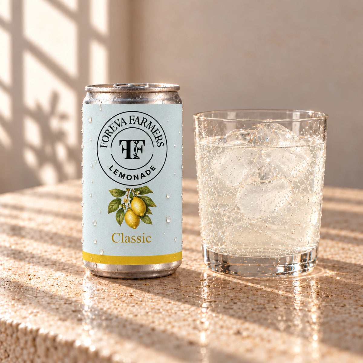 Foreva Farmers Sparkling Lemonade 150ml can with an iced drink on a sunlit stone table